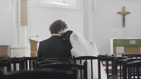 pareja sentada en la iglesia durante la ceremonia de bodas