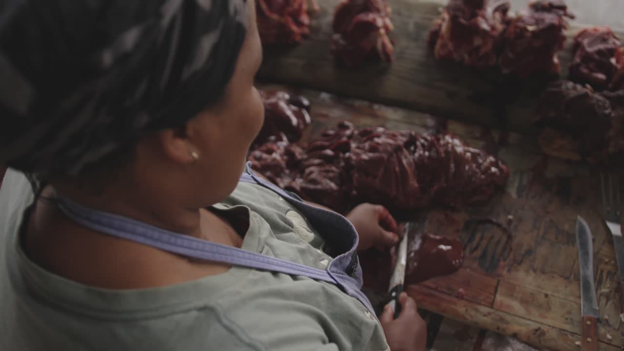 African woman cutting the meat