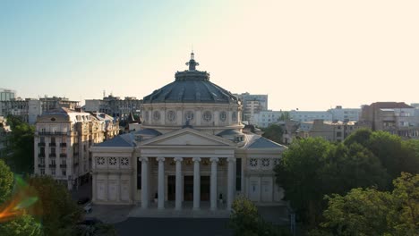 Top-Down-View-Over-The-Romanian-Athenaeum-At-Sunrise-In-Bucharest-Surrounded-By-Tall,-Historic-Buildings