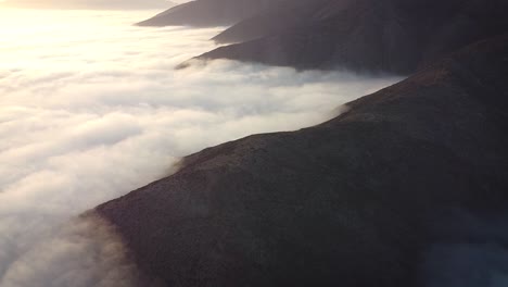 mountains and a mattress of clouds during and amazing sunrise in the desert of lima peru