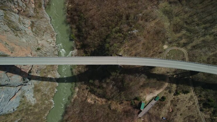 Drone footage looking down at cars driving over the Durdevica Tara Bridge with the Tara river below