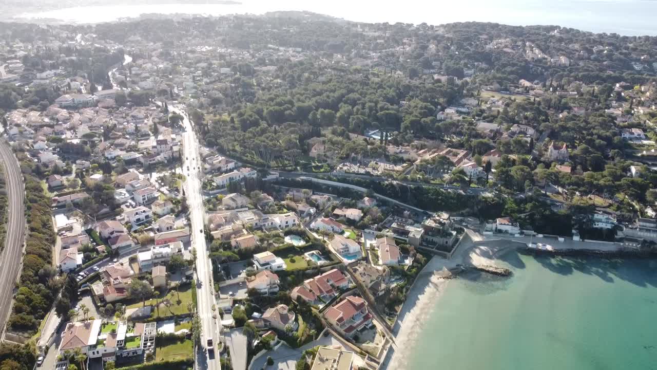 drone perspective pans against the horizon from the bay of bandol towards the beautiful city of sanary in the south of france, perfect sunny weather