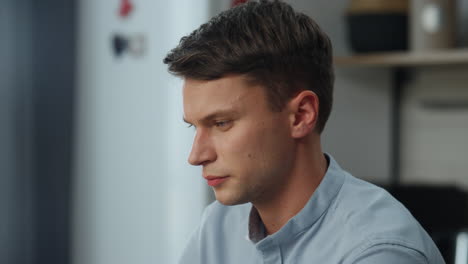 portrait thoughtful man working at home. businessman doing job tasks in kitchen.