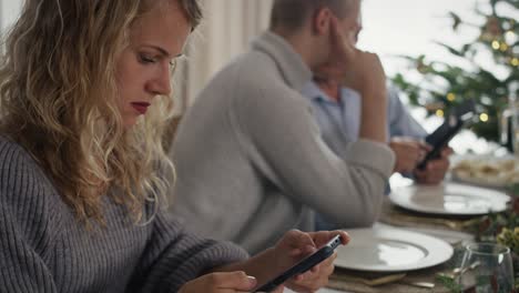 mujer caucásica pasando la víspera de navidad con el teléfono móvil.