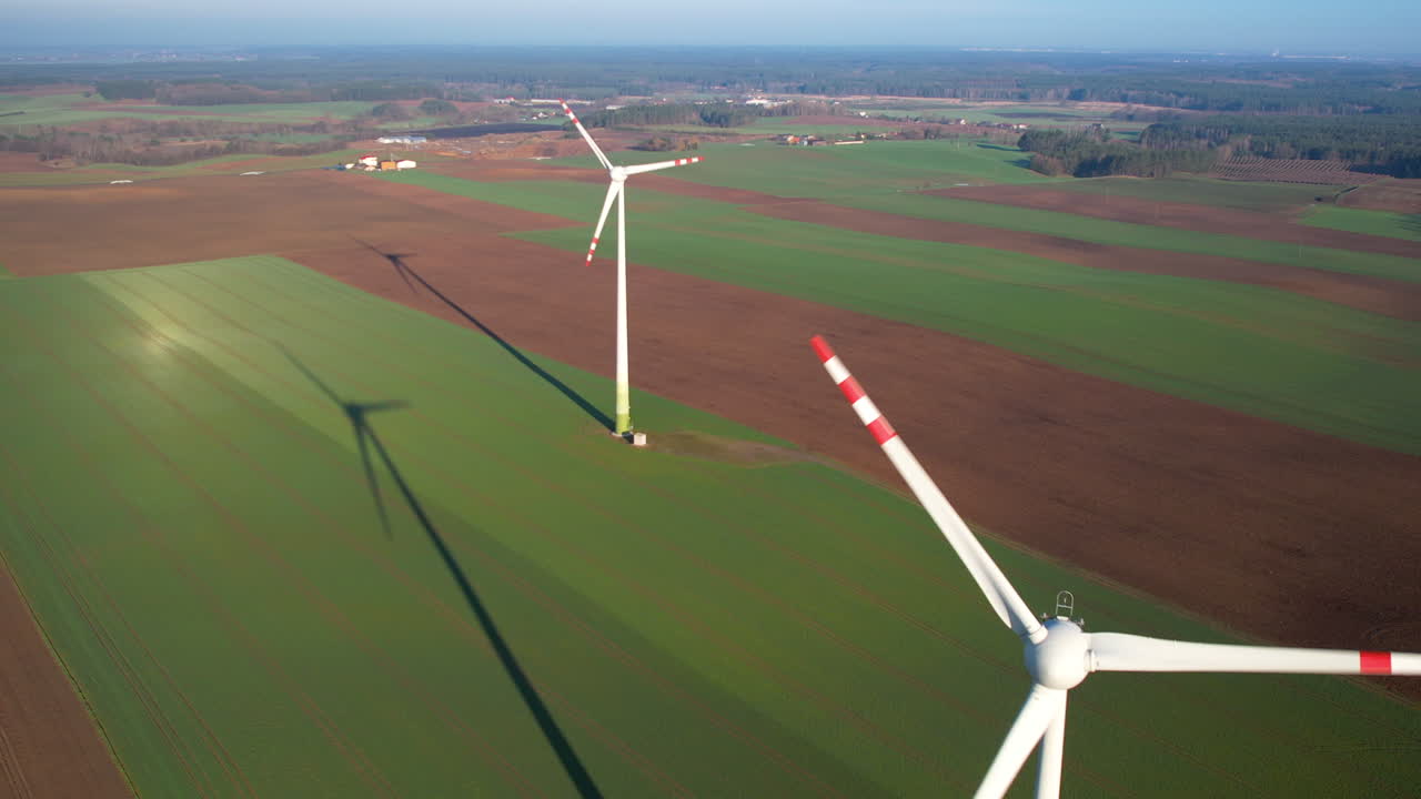 Panoramic aerial view of wind farm or wind park on sunny day, with high wind turbines for generation electricity