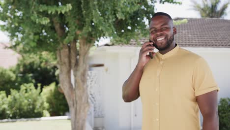 Portrait-of-happy-african-american-man-talking-on-smartphone-in-garden,-copy-space,-slow-motion