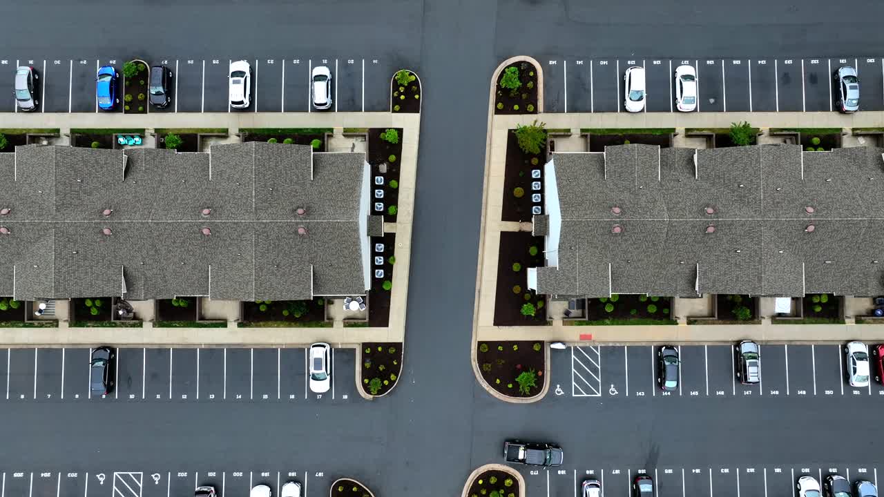 Large Parking area in new developed housing area. Grey roofs of houses in american suburb. Aerial top down rising shot.