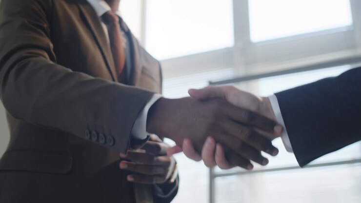 Black Businessman Giving Handshake to Colleague in Office