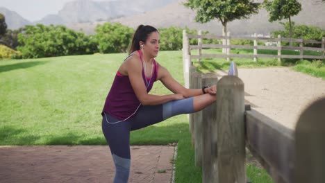 mujer caucásica estirándose en un parque