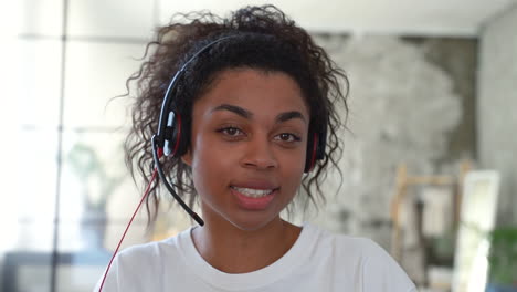 retrato de una joven negra haciendo una videollamada. una chica trabajando a distancia mirando a la cámara.