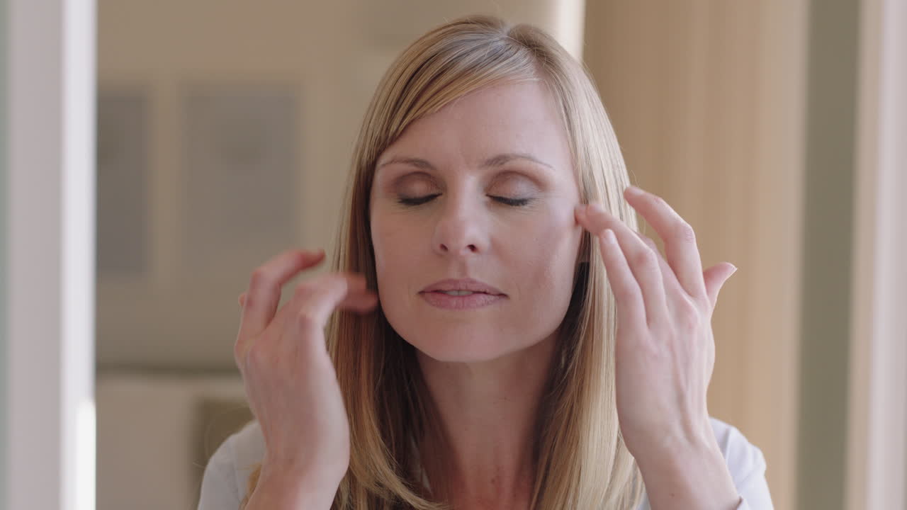 портрет красивой блондинки, наносящей макияж, готовящейся дома, глядя в зеркало, наслаждающейся утренней подготовкой, гладкой естественной кожей