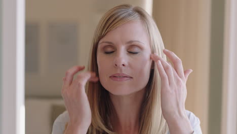 Retrato-Hermosa-Mujer-Rubia-Aplicando-Maquillaje-Preparándose-En-Casa-Mirándose-En-El-Espejo-Disfrutando-De-La-Preparación-De-La-Mañana-Tez-Suave-Y-Natural