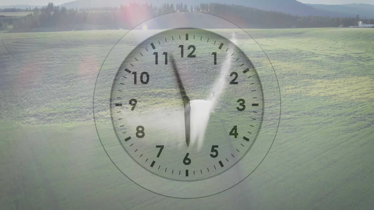 Appearing translucent clock starting hands turning over fields, streak moving, showing time-lapse