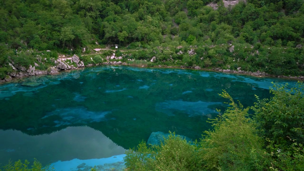 Plynulý pohyb kamery odhalující křišťálově čisté tyrkysové vody jezera Lago Cornino ve Furlánsku v Itálii