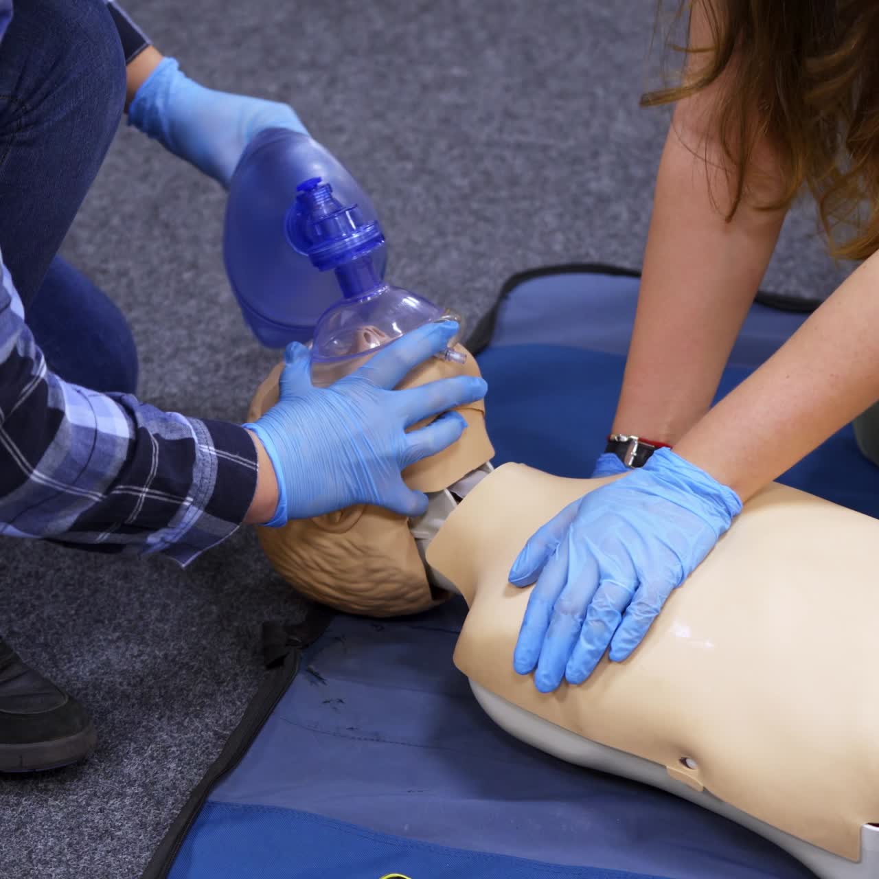 Medical dummy doll lays on blue blanket ready for training. First medical help with oxygen masks. First aid help