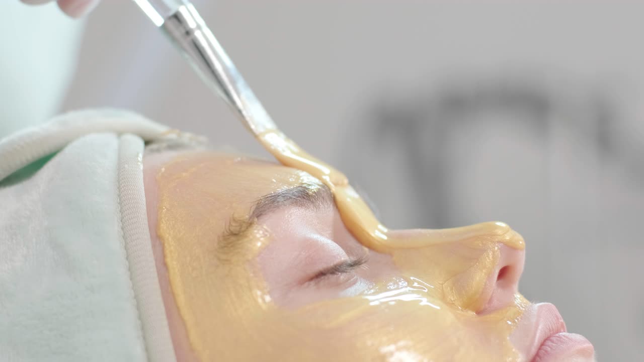 Profesjonelle ansiktspleieprosedyrer på en moderne kosmetologiklinikk. Hudpleier utfører ansiktsbehandlinger – rensing, maske, peeling, karboksyterapi.