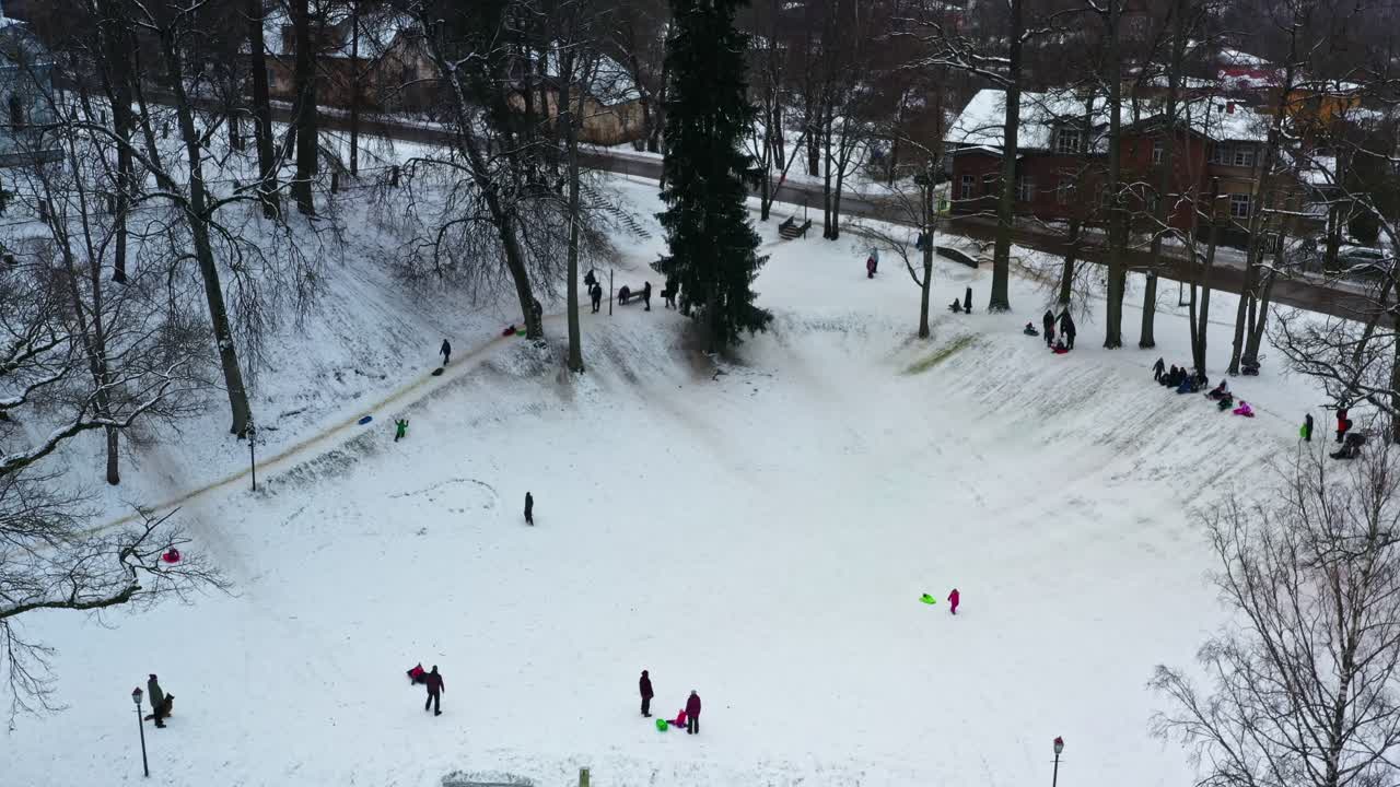 Mensen die plezier hebben tijdens het sleeën van besneeuwde heuvels in een populair winterpark