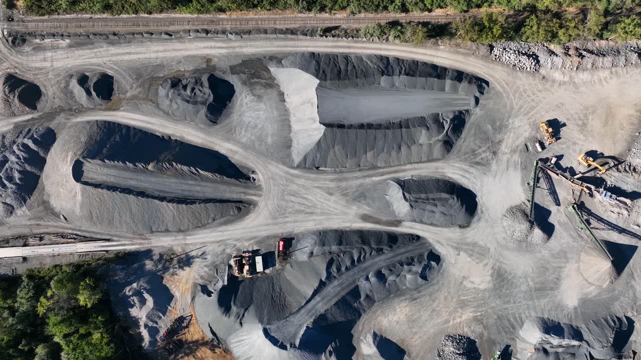Top down aerial of large piles of stones and rock at mining facility