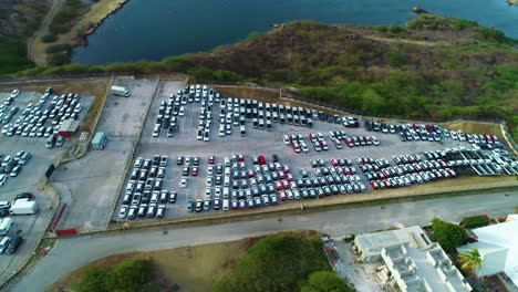 coches blancos y negros estacionados en el transporte industrial importación exportación mucho, aumento aéreo inclinación hacia abajo