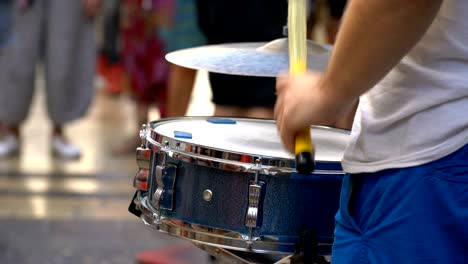 a street musician plays beautifully on the snare drum, the drum on a summer day.