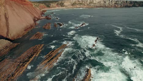 coastal rocky landscape with red cliffs and waves