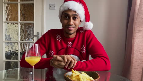 young man on christmas video call reacting to someone opening christmas present