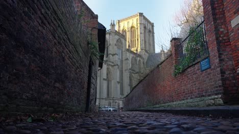 movimiento lateral de la gran catedral desde un ángulo bajo en un callejón empedrado en la ciudad histórica de york