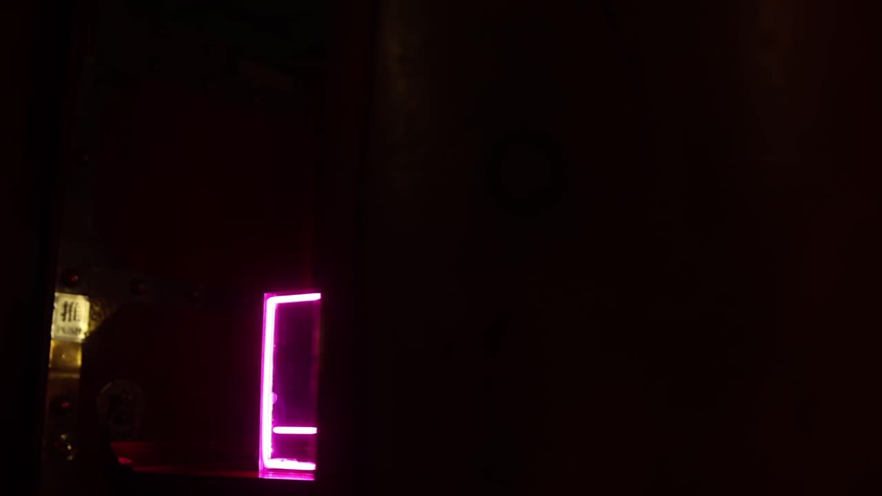 letrero de neón rosa iluminado con texto abierto en caracteres chinos que brilla por la noche contra un fondo negro