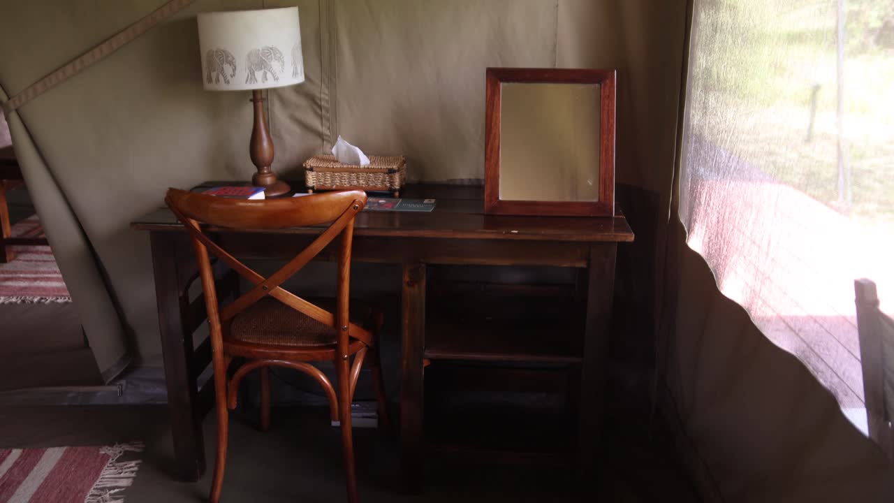 interior of safari tent with desk and lamp on safari on the Masai Mara Reserve in Kenya Africa