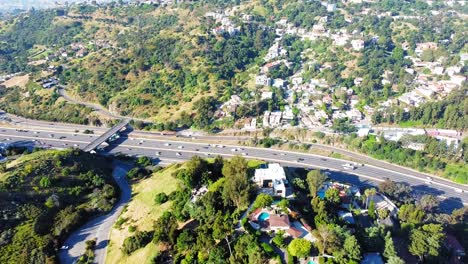 aerial view of a highway and houses in a hilly landscape