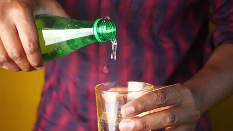 un hombre vierte un refrescante refresco en un vaso