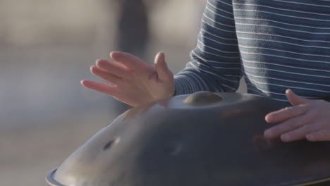 Woman-outdoors-tapping-her-hands-on-a-metal-object