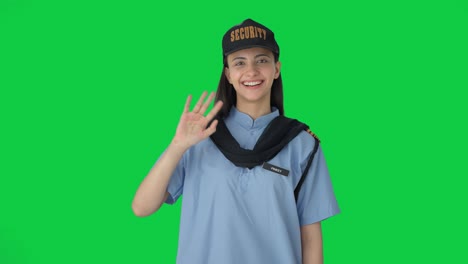 happy indian female security guard waving hello green screen