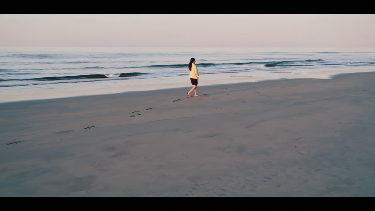 Woman Walking on the Beach at Sunrise/Sunset