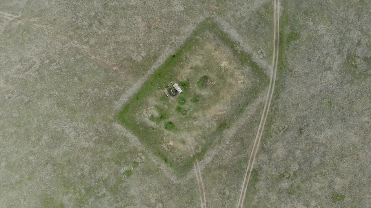 Aerial View of a Small Rectangular Enclosure in a Grassy Field