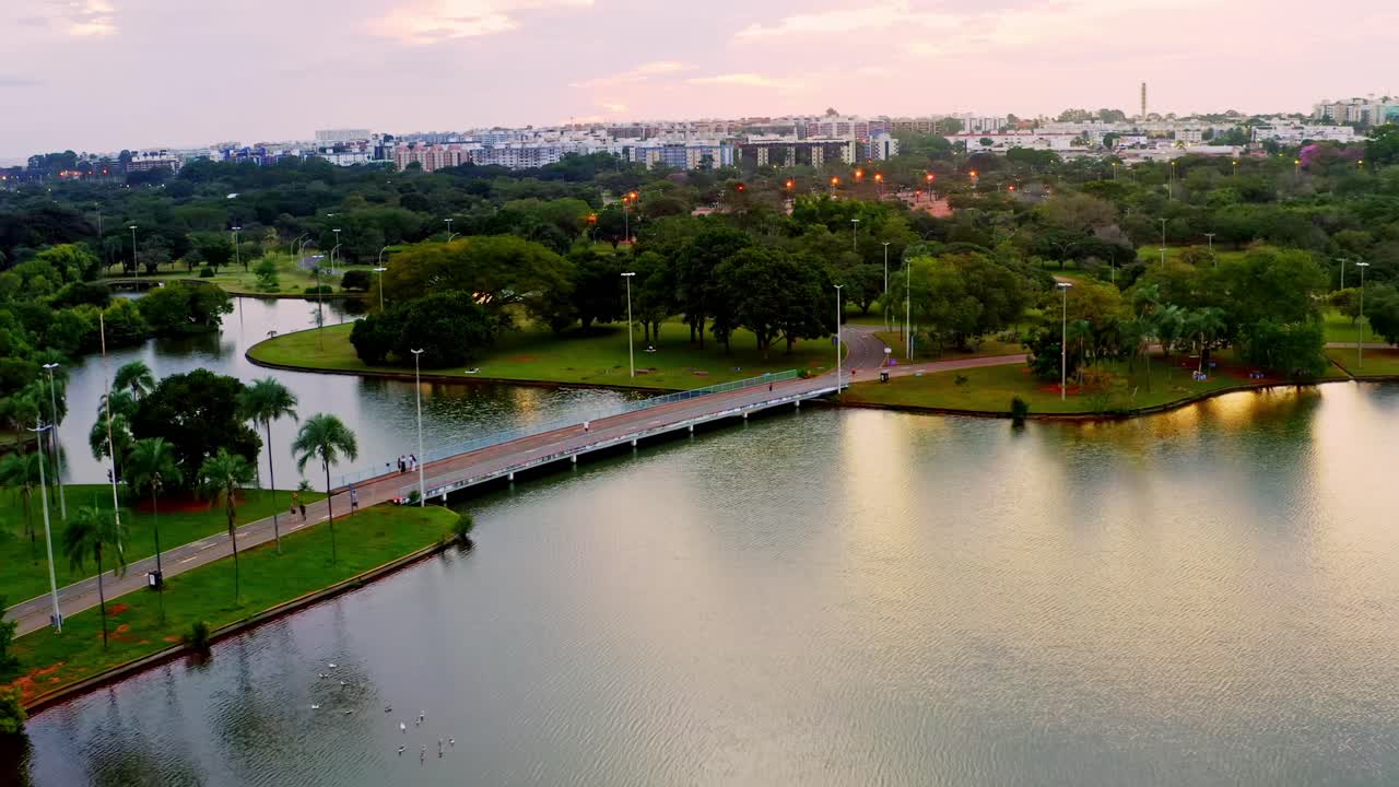 aerial de la noche del parque de la ciudad de brasilia con puente peatonal y lago
