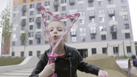 girl playing with bubbles in a park