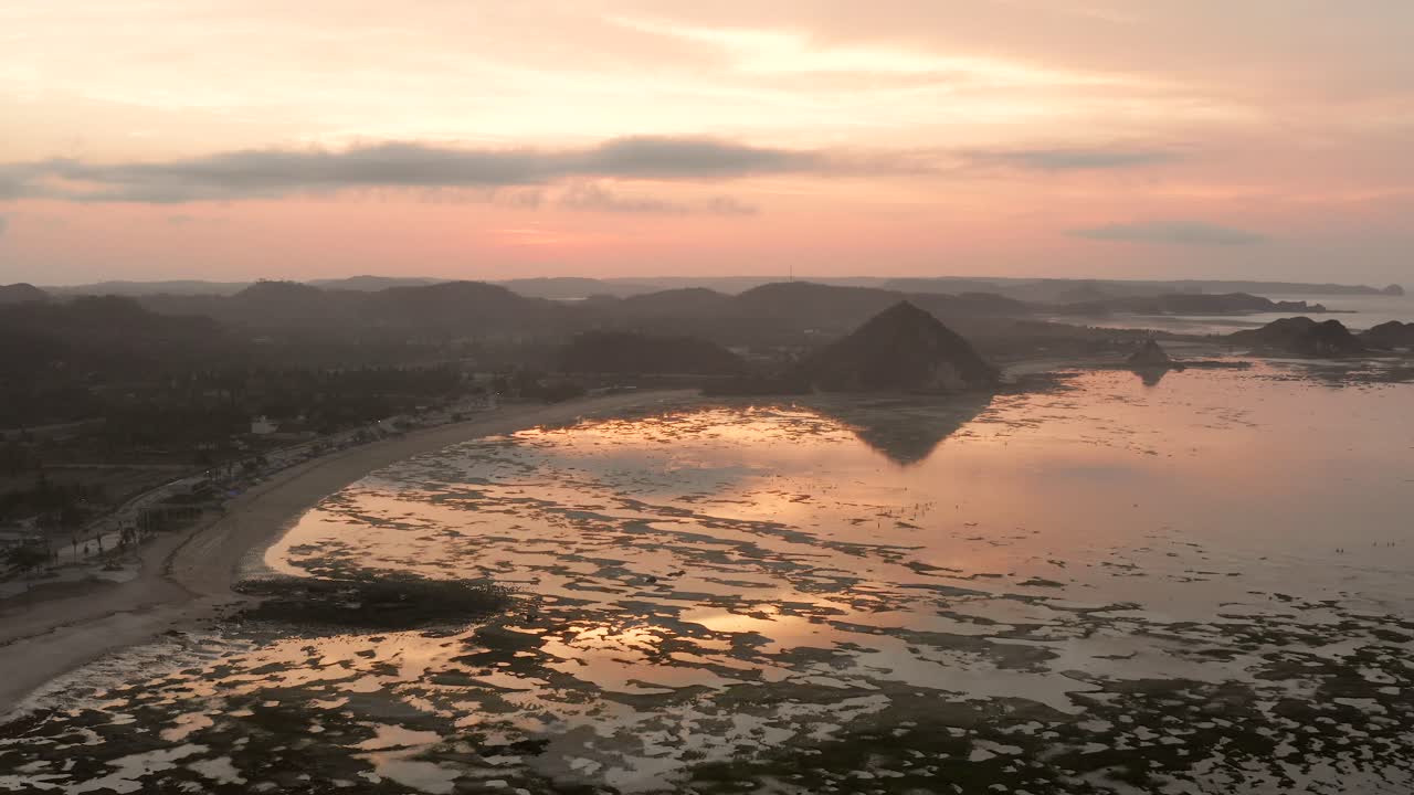 el arrecife seco de kuta lombok durante el amanecer, con gente local buscando comida y conchas marinas