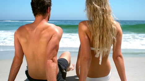pareja sentada en la arena en la playa