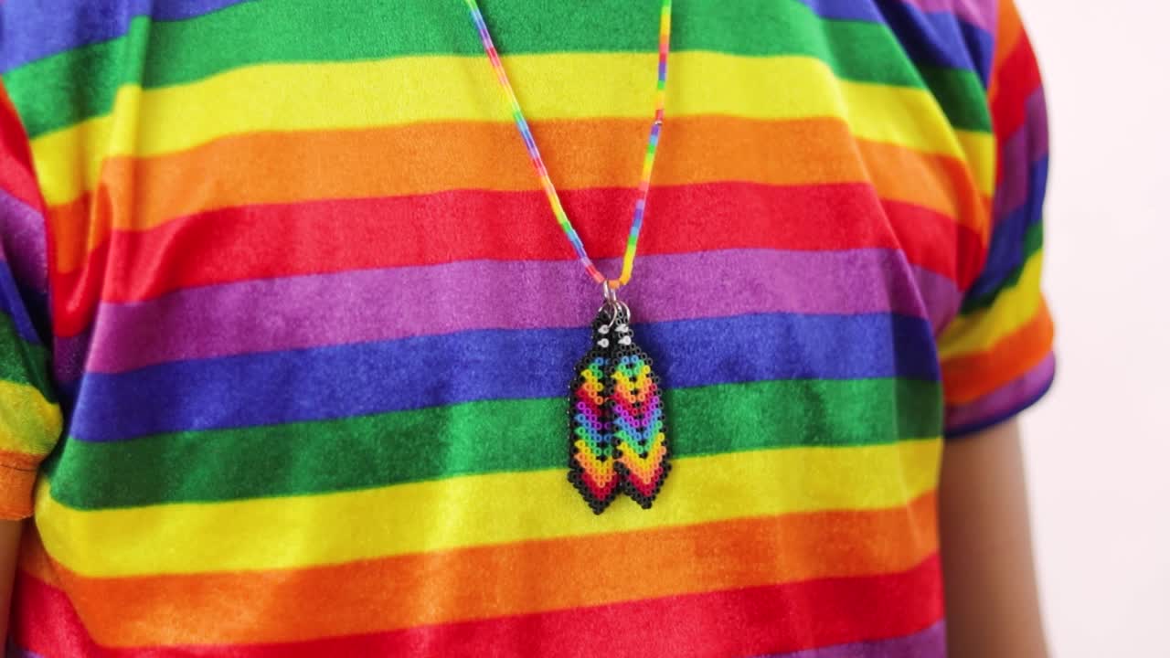 camiseta y collar de orgullo lgbtq arco iris en un joven gay, disparo de detalle