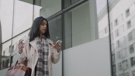 Businesswoman-using-smartphone-outdoors.-Busy-girl-walking-on-street-in-hurry