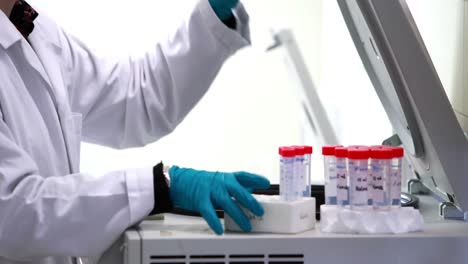 scientist placing test tubes in centrifuge