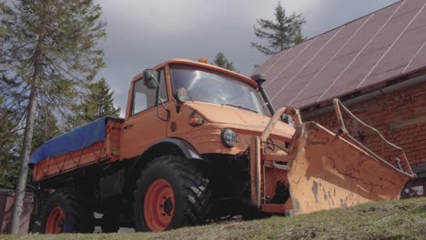 orange mercedes-benz unimog snow plow truck in a rural setting
