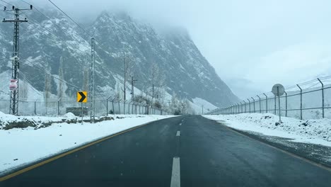 car driving on a road in skardu in landscape covered with snow and high mountains