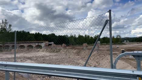 excellent filming from a car where we see the demolition of an old bridge due to a very strong flood and the preparation of a new one, we erect the new pillars, there are machines working