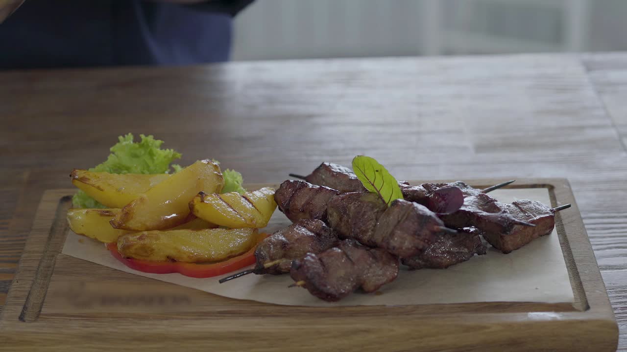 chef es sal y pimienta un hermoso servido verduras frescas, patatas grasas y plato de kebab en el pan pita