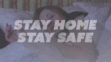 Animation-of-text-Stay-Home-Stay-Safe-over-Caucasian-woman-sleeping