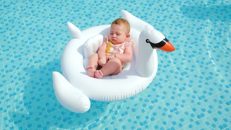 baby swims in a circle in the pool. selective focus.