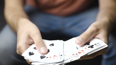 male hands shuffle playing cards and browse through deck, close-up