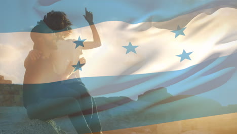 animación de la bandera de honduras sobre una pareja afroamericana en la playa